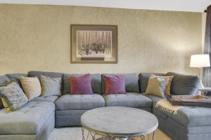 ein Wohnzimmer mit einer blauen Couch mit bunten Kissen in der Unterkunft PARK STATION 122 condo in Park City + 22 Fotos