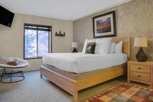 ein Schlafzimmer mit einem großen Bett und einem Stuhl in der Unterkunft PARK STATION 122 condo in Park City