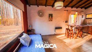 sala de estar con sofá azul y cocina en Cabañas en Malargue en Malargüe