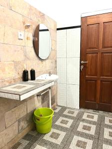 a bathroom with a sink and a green bucket at Derawan Fisheries Cottage in Derawan Islands