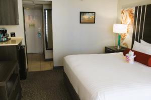 a hotel room with a bed and a kitchen at Elevated Aqua Palms Waikiki Studio condo in Honolulu
