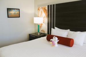 a hotel room with a bed with a stuffed animal on it at Elevated Aqua Palms Waikiki Studio condo in Honolulu