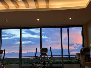 a gym with a large window with a view of the sky at Grand Riviera Suites in Manila