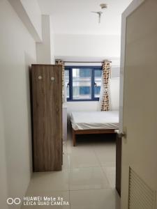 a small bedroom with a bed and a window at Grand Riviera Suites in Manila