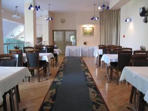 a dining room with tables and chairs with white table cloth at Hotel Carmen in Karpacz
