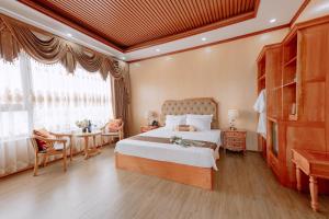 um quarto com uma cama, uma mesa e uma janela em Tuan Nam Hotel em Haiphong