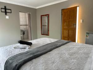 a bedroom with a bed with a cross on the wall at Dee Park Entertainment Centre in Thohoyandou