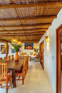 a dining room with a wooden ceiling and a table and chairs at Casas Orixás em Trancoso in Trancoso