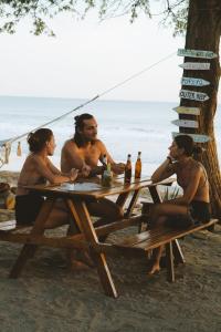 a group of people sitting at a picnic table on the beach at Popoyo Republic in Popoyo