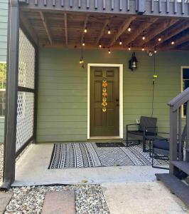 a green house with a door and a bench at 2 BR 1 BA apartment in Newnan