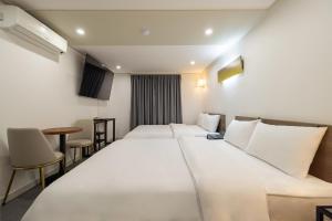 ソウルにあるHotel Stay Innの大きなベッドとテーブルが備わるホテルルームです。