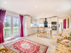 a kitchen and living room with a table and chairs at Paddock Barn in North Nibley