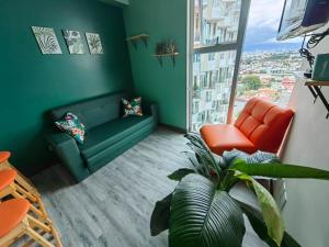 a living room with a green couch and a window at 1515 SECRT Sabana Hermoso Apartamento Totalmente Equipado in San José