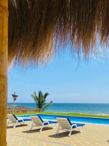 una fila de sillas sentadas junto al océano en Hotel Gran Azul Bungalows en Canoas de Punta Sal