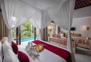 a bedroom with a large bed and a pool at Kawi Resort A Pramana Experience in Tegalalang