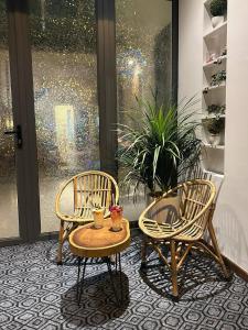 two chairs and a table in front of a window at Gachilly House - Your Cozy Home In The Heart Of The BMT City in Buon Ma Thuot