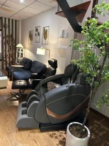 a living room with a couch and a chair and a tree at Gachilly House - Your Cozy Home In The Heart Of The BMT City in Buon Ma Thuot