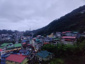 a view of a city with buildings and a mountain at Keswani Group Tashi Heritage Hotel & Resort in Gangtok