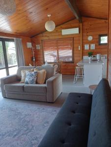 a living room with a couch and a kitchen at Cosy in central Rotorua in Rotorua