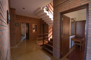 a hallway with a staircase and a brick wall at Nisargha Serviced Apartments in Bangalore