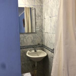 baño con lavabo y cortina de ducha en Pedraza house Airport, en Lima
