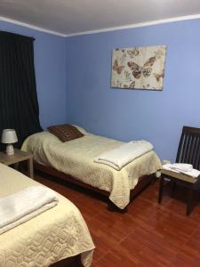 2 camas en una habitación con paredes azules en Pedraza house Airport, en Lima