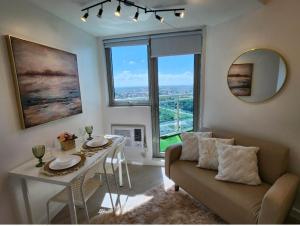 uma sala de estar com uma mesa e um sofá em Big Balcony - Relaxing Condo in San Fernando em San Fernando