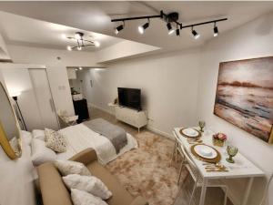 Schlafzimmer mit einem Bett, einem Tisch und einem TV in der Unterkunft Big Balcony - Relaxing Condo in San Fernando in San Fernando