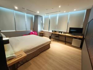 a bedroom with a bed and a desk with a computer at Walker-Taoyuan in Taoyuan