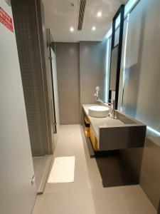 a bathroom with a sink and a mirror and a shower at Walker-Taoyuan in Taoyuan