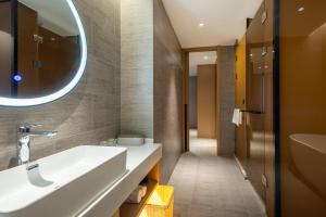 a bathroom with a white sink and a mirror at Atour Hotel Xiamen Meifeng Binhai Romantic Line in Tong'an +21 photos