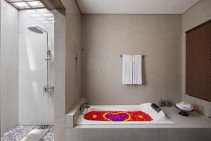 La salle de bains est pourvue d'une baignoire remplie de fleurs. dans l'établissement Kawi Resort A Pramana Experience, à Tegalalang