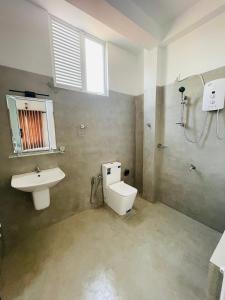 a bathroom with a toilet and a sink and a shower at Devo's place in Galle
