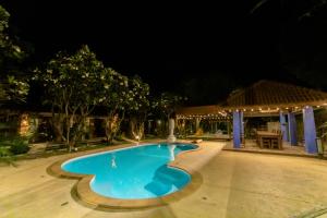 una piscina por la noche con cenador en Namsai Resort Kanchanaburi, en Kanchanaburi