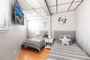 twee bedden in een kleine kamer met een nautische bij Chain O' Lakes Beach Penthouse with Lake Access in Ingleside