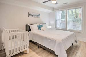 Opuluxe Chic Spacious Urban Oasis في أتلانتا: غرفة نوم بيضاء مع سرير أطفال ونافذة
