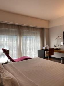 クアラルンプールにあるAlia Premier KLCCのベッド1台、椅子、窓が備わる客室です。