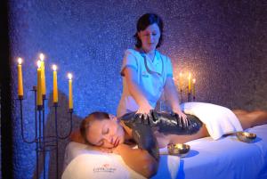 a woman laying on a bed next to a man at Wellness Hotel Apollo – Terme & Wellness LifeClass in Portorož
