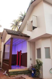 uma casa com luzes roxas na frente em VILLA CASA SUMANJO (3BHK) em Calangute