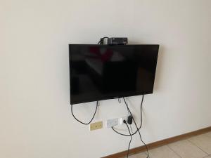 TV de pantalla plana colgada en la pared en Hermoso apartamento pulpos, en Punta Hermosa