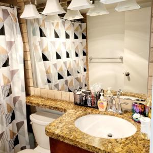 uma casa de banho com um lavatório, um WC e um espelho. em High rise Near UNLV and Strip em Las Vegas