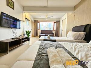 a hotel room with two beds and a television at Bangsar Three Storey Luxury Landed House 19PAX in Kuala Lumpur