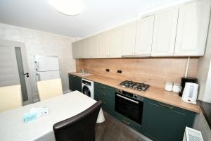 a kitchen with green cabinets and a stove top oven at FLY - Regim Hotelier Galati in Galaţi +7 photos