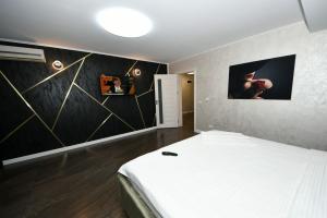 a bedroom with a white bed and a black wall at FLY - Regim Hotelier Galati in Galaţi