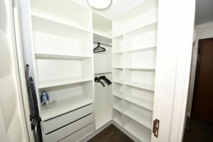 a walk in closet with white shelves at FLY - Regim Hotelier Galati in Galaţi