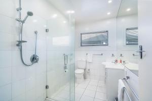 a white bathroom with a shower and a toilet at Sunny Richmond Retreat in Richmond