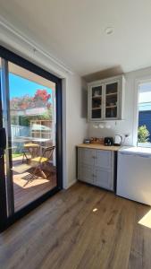 a kitchen with a sliding glass door leading to a patio at Beach Break Cabin 1 in Pohara