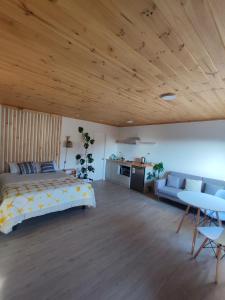 a bedroom with a bed and a couch and a table at Departamento Concepción Tomé Cocholgüe in Tomé