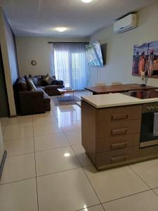 een keuken en een woonkamer met een bank en een tafel bij MERENSKY Windhoek in Windhoek