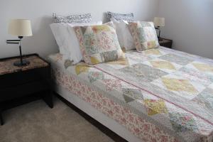 a bedroom with a bed with a quilt and pillows at Pátio Mateus in Areia Branca